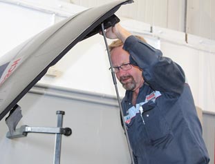 Mechanic lifting hood of car