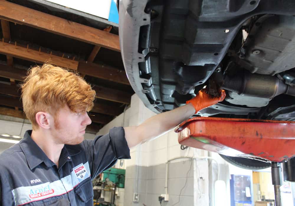 Young mechanic performing a car servicing in Hamilton.