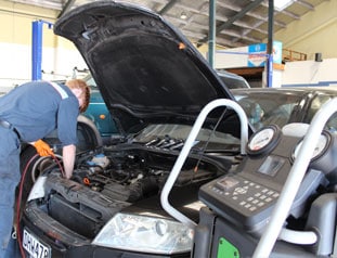 Young mechanic using diagnostics tools on car