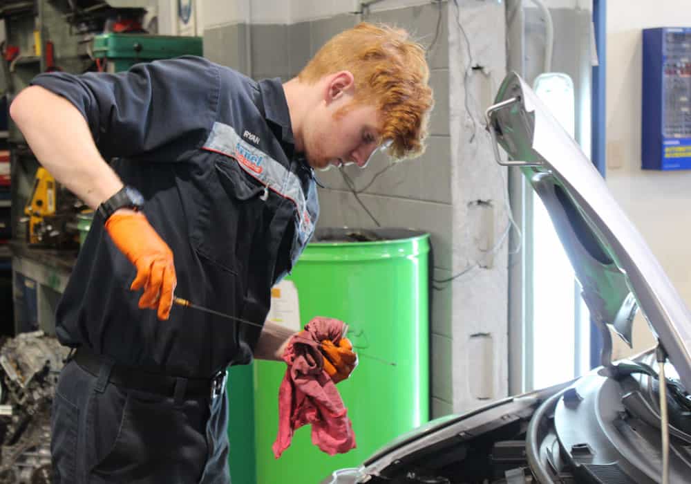 Young mechanic performing an oil check during a car service hamilton