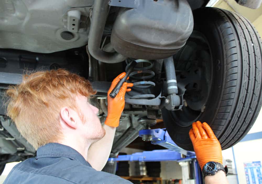 Young mechanic using diagnostics tools on car