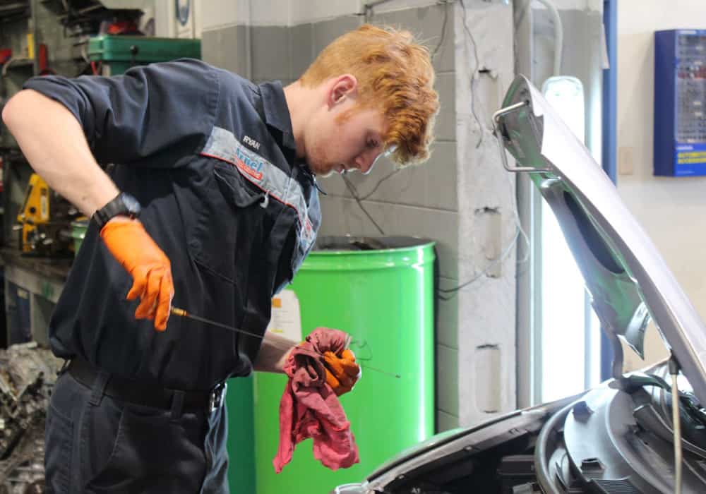 Young mechanic using diagnostics tools on car