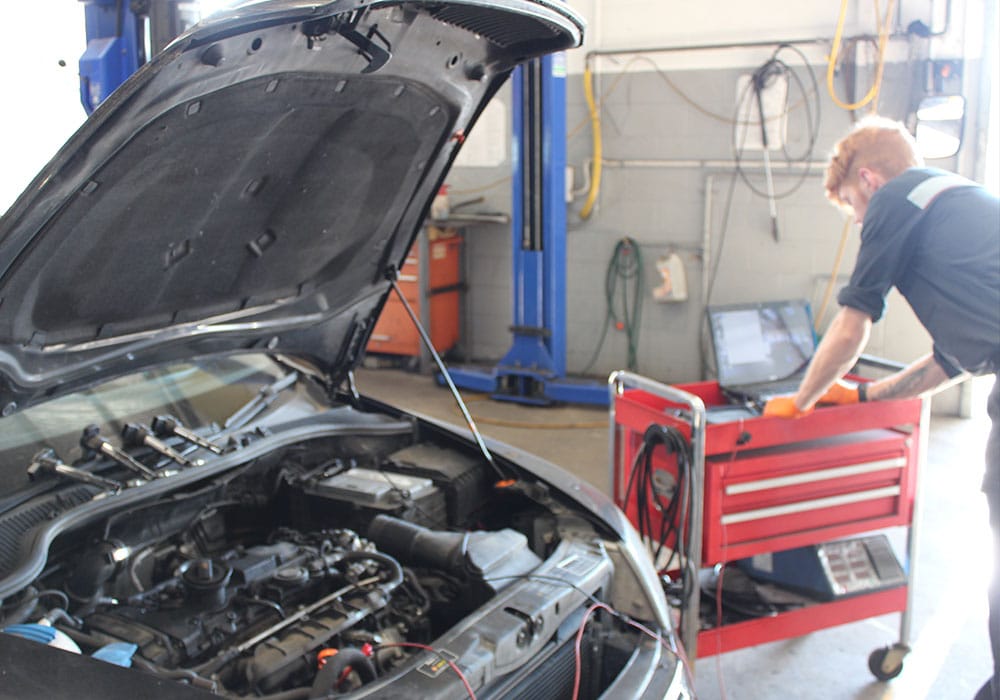young mechanic under taking a car servicing